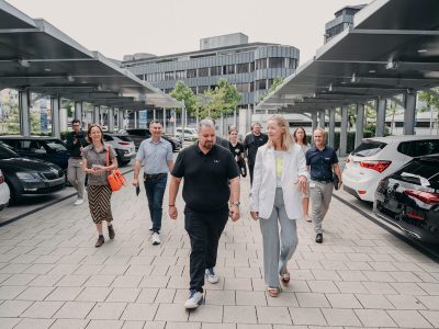 Das SolarTech-Startup hat sein erstes modulares Solarkraftwerk errichtet. Es überdacht 21 Stellplätzen auf dem Areal der Volksbank, das somit insgesamt nahezu 60kWp an erneuerbarer Energie liefert. Im Bild: UV-Energy Geschäftsführer Felix Gerhard und Baden-Württembergs Umweltministerin Thekla Walker bei der Besichtigung der Anlage.