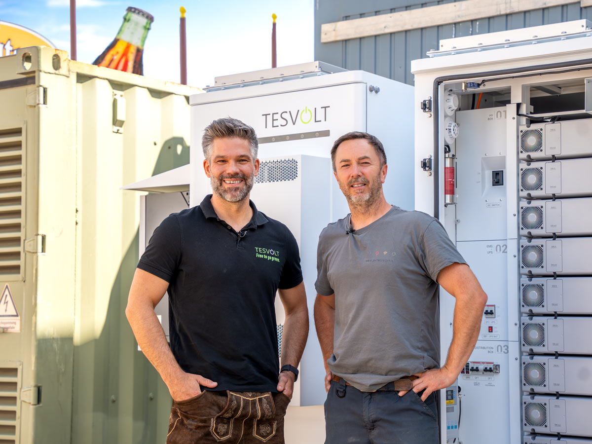 Markus Borke, Area Manager bei TESVOLT (links), und Matthias Poeting, Geschäftsführer von MP Elektrotechnik München bei der Installation der Gewerbespeicher auf der Festwiese.